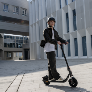 Usuario conduciendo patinete Segway Ninebot F2 Pro E II en entorno urbano moderno
